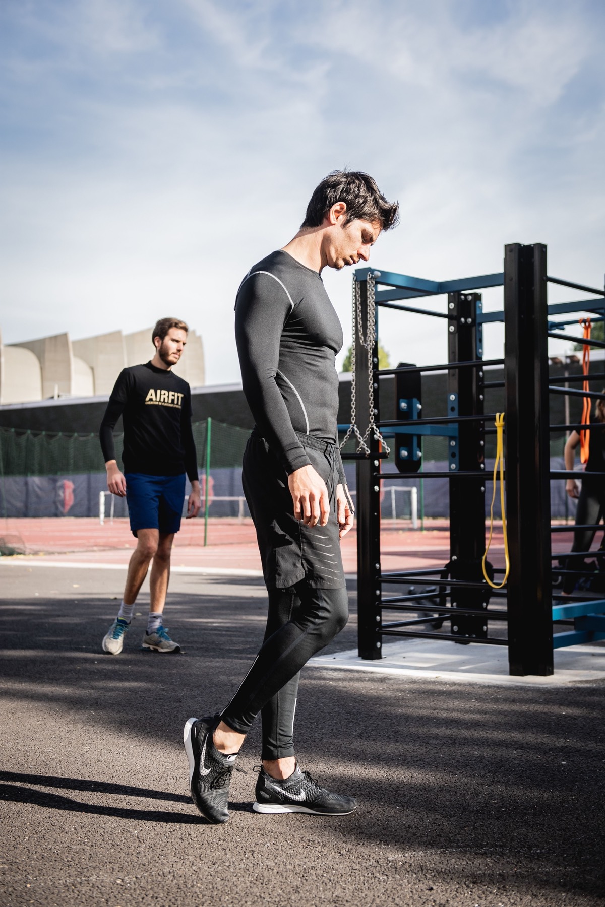 Two athletes training outdoors in baselayers and joggers